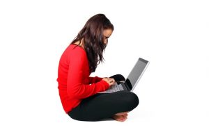 Woman sitting cross-legged with a laptop in her lap